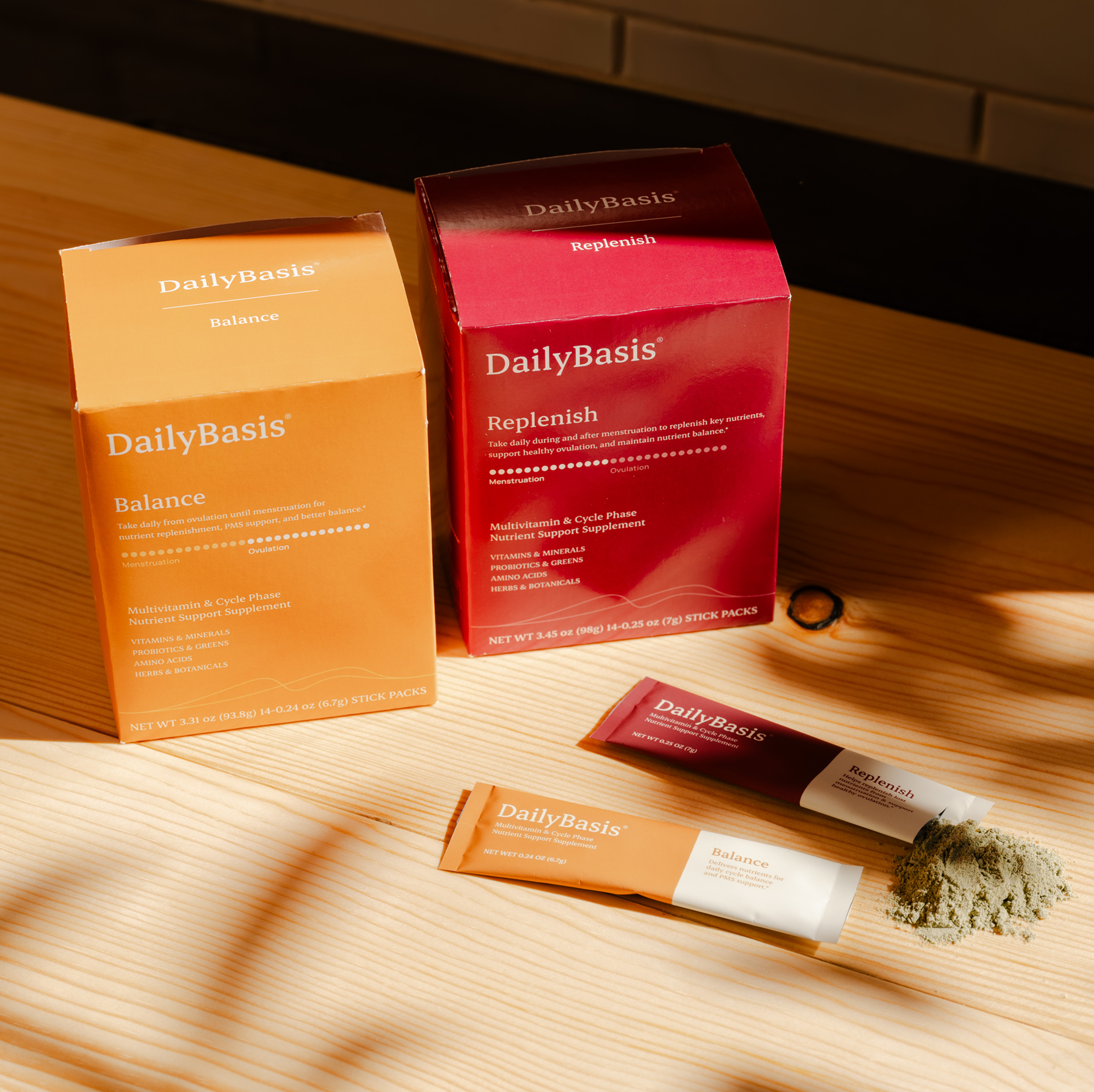 DailyBasis Cycle Routine supplement boxes with stick packs and powder in lifestyle context